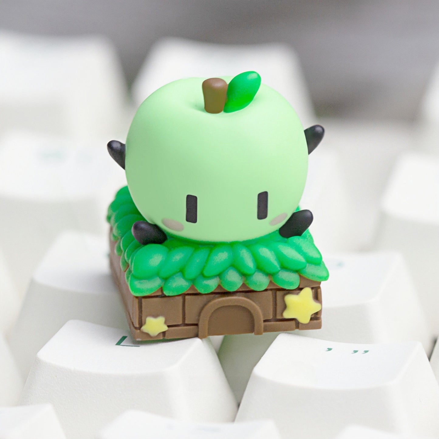 Keycapper custom green Junimo artisan keycap with a cute apple sprite and miniature hut on a mechanical keyboard.