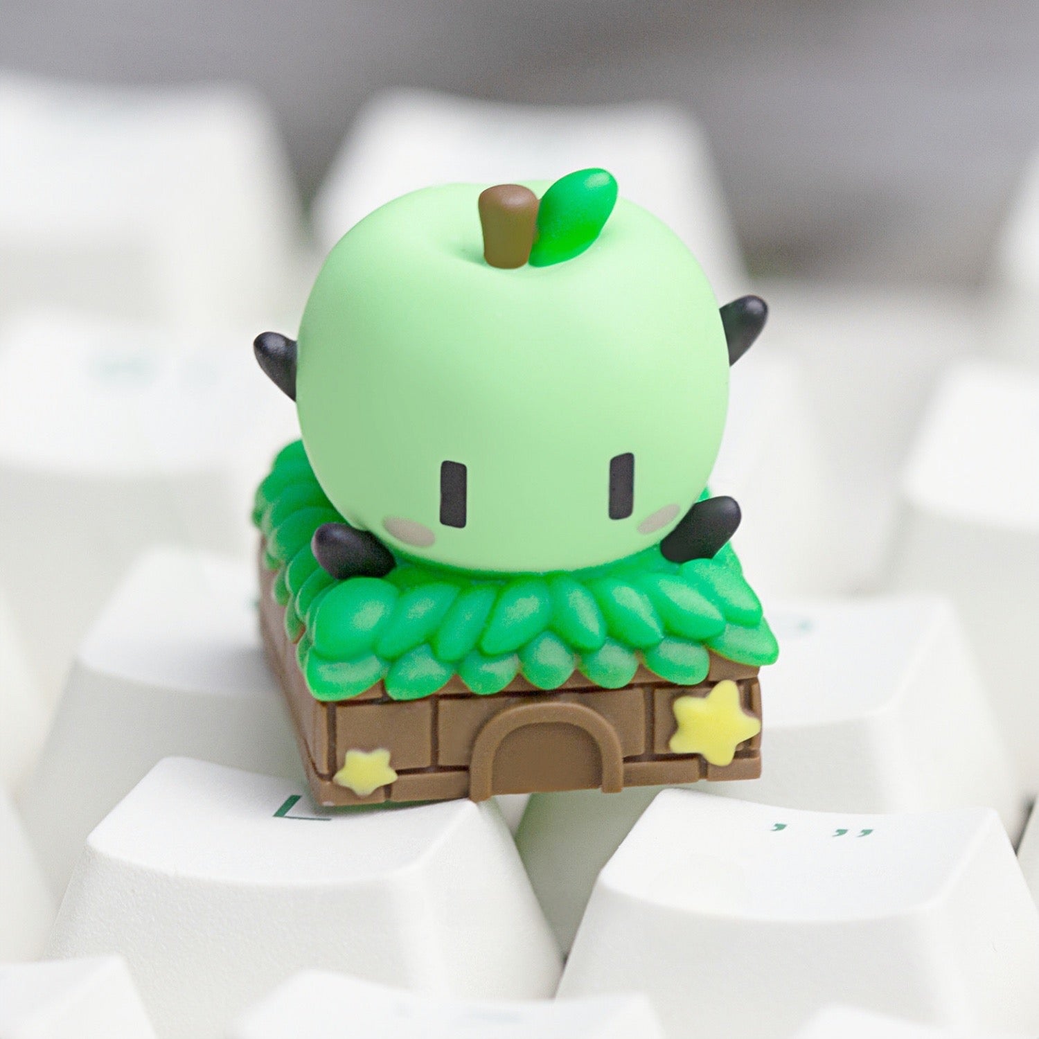 Keycapper custom green Junimo artisan keycap with a cute apple sprite and miniature hut on a mechanical keyboard.