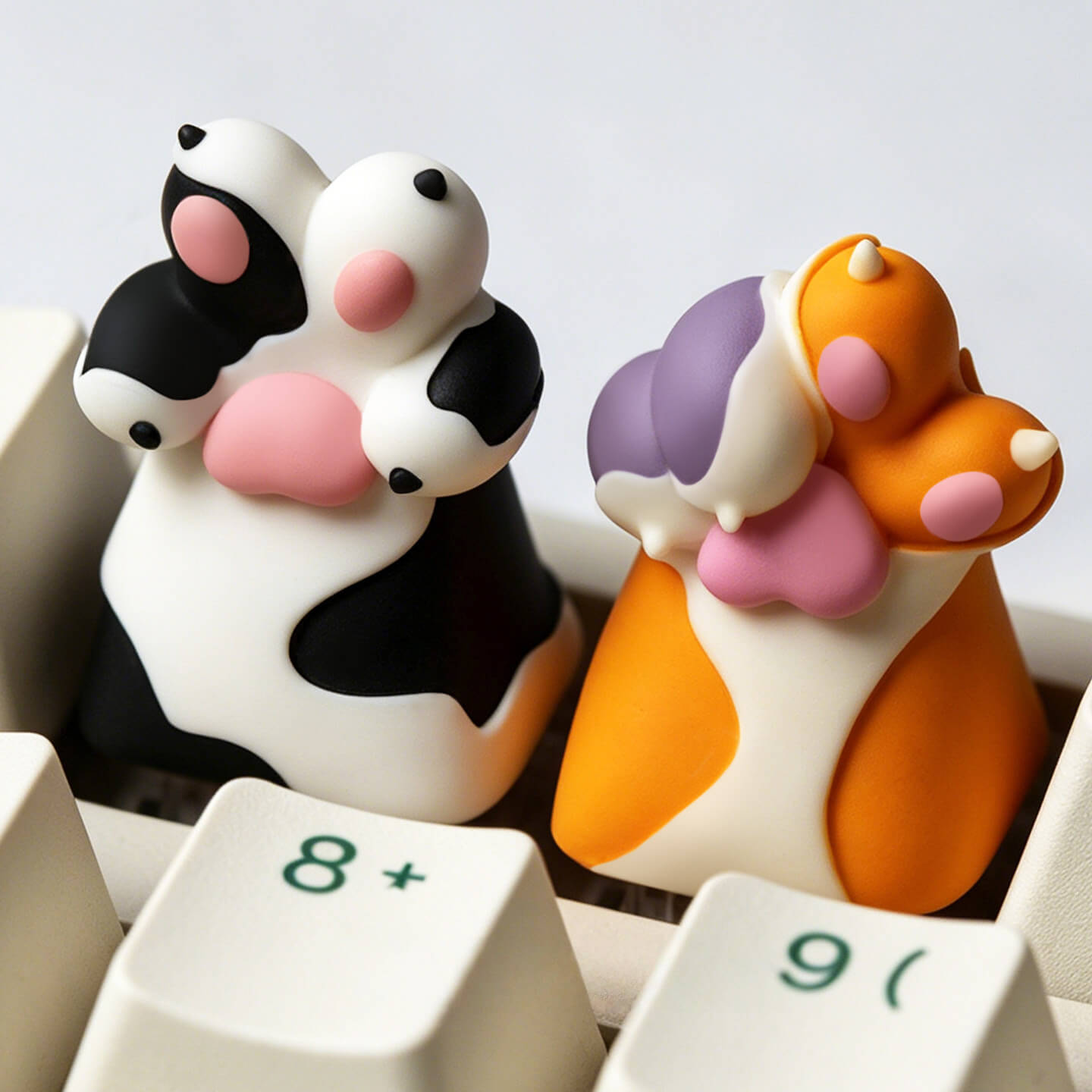 Keycapper black and white spotted dog paw and orange calico cat paw resin artisan keycaps mounted on a vintage mechanical keyboard.