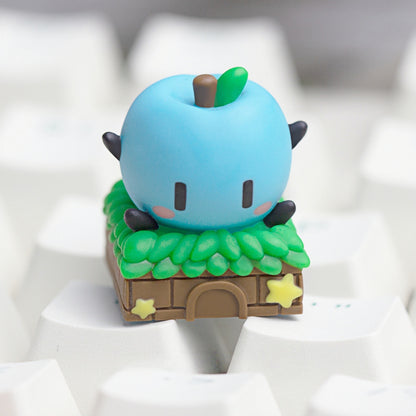 Keycapper sky blue Junimo apple sprite custom keyboard keycap with detailed thatched roof hut design.