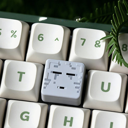 Keycapper™ Minecraft Cube Series Artisanal Keycap – A focused shot of a textured 3D voxel-style Stray mob head keycap (ice skeleton variant), grey and textured, installed on a white mechanical keyboard 'T' key, surrounded by white keys and green accents.