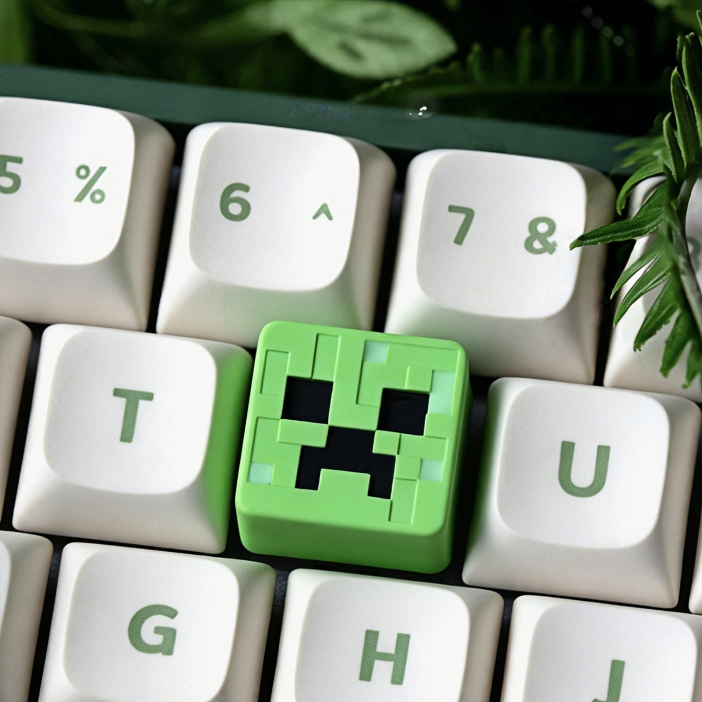 Keycapper™ Minecraft Cube Series Artisanal Keycap – A vibrant 3D voxel Creeper face novelty keycap, lime green with distinct black pixel eyes and mouth, positioned on a white mechanical keyboard next to green legends.