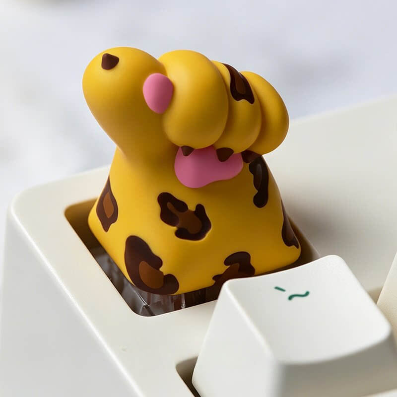 Keycapper yellow leopard print paw resin keycap with brown spots and pink pads on a mechanical keyboard.