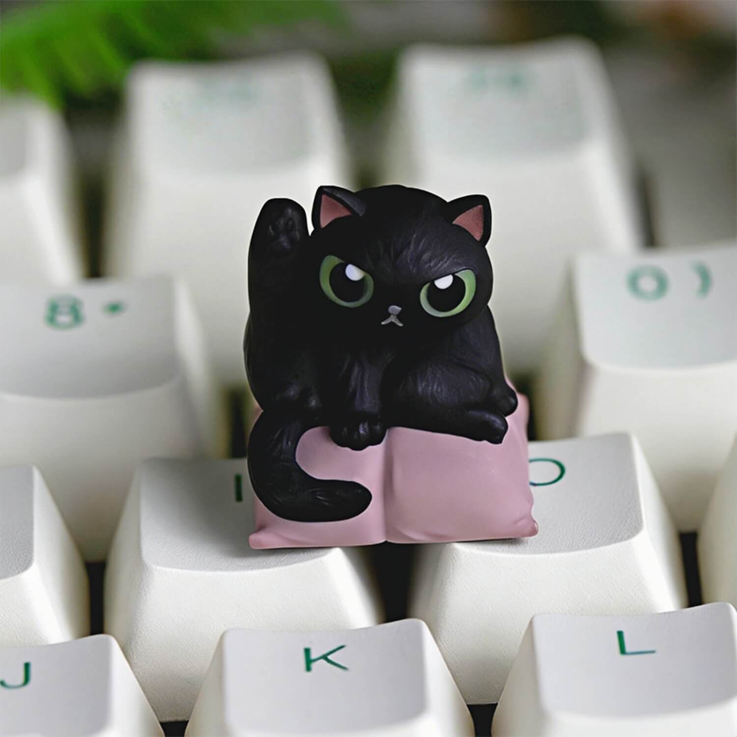 Keycapper Cat Grooming artisan keycap featuring a mysterious black cat with green eyes lifting its leg on a soft pink cushion.