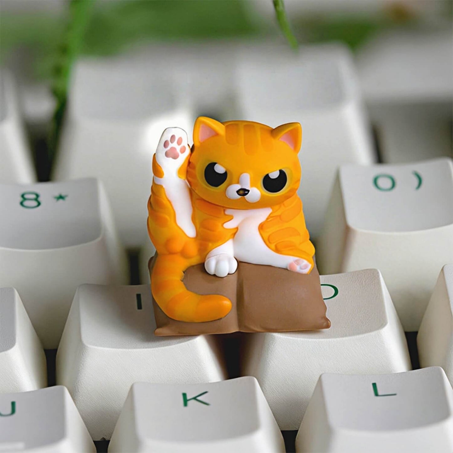 Keycapper Cat Grooming artisan keycap featuring a chubby orange tabby cat doing a leg stretch pose on a brown cushion.