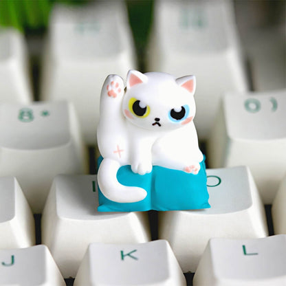 Keycapper Cat Grooming artisan keycap featuring an elegant white cat with heterochromia odd eyes lifting its leg on a bright blue cushion.